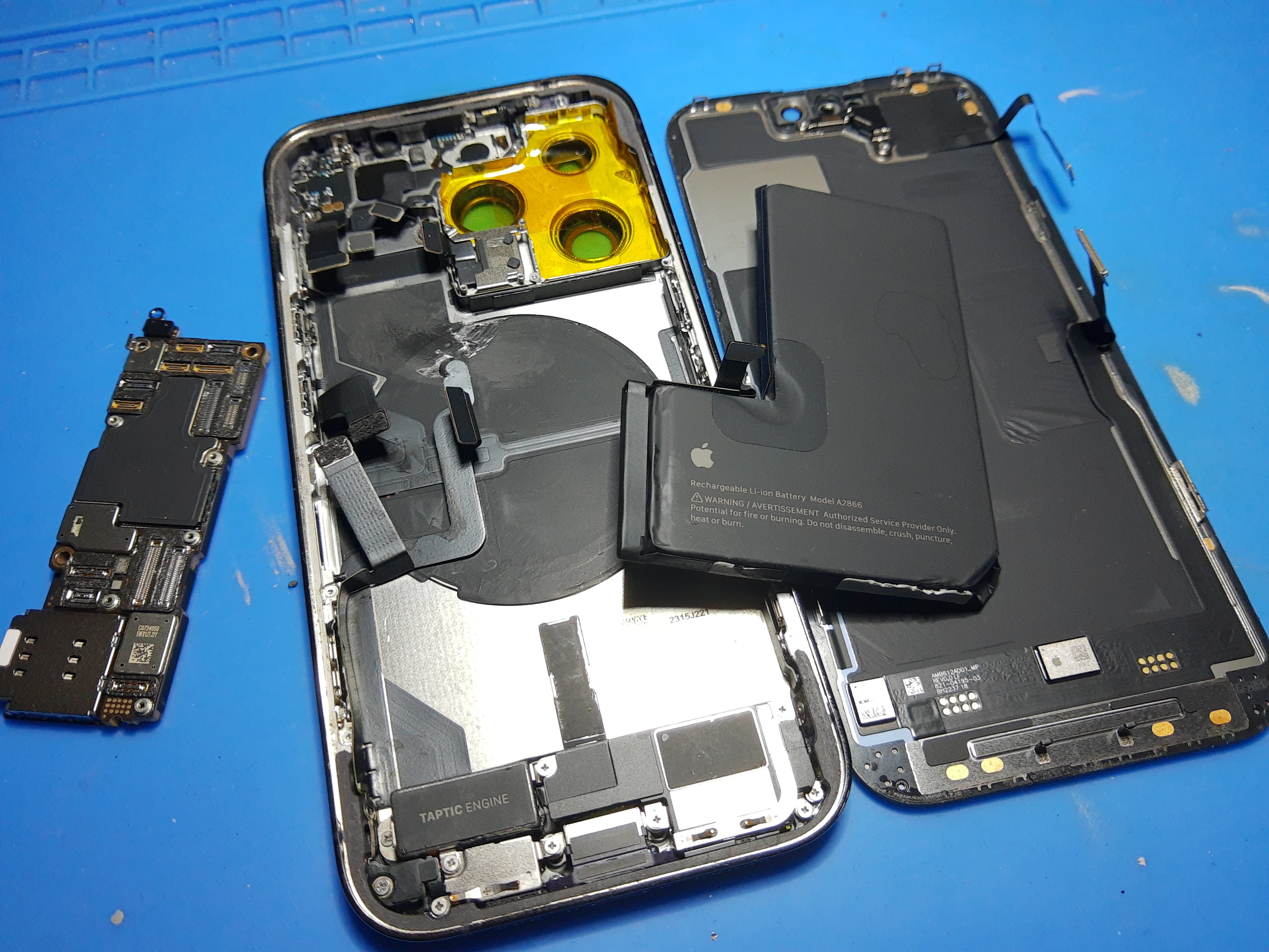 Componentes desmontados de un iPhone 14 Pro durante el cambio de cristal trasero