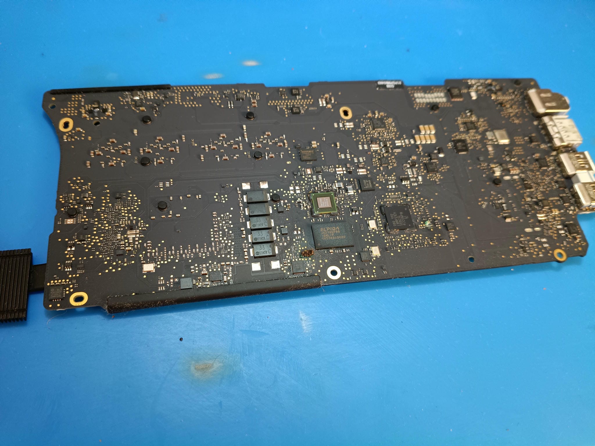 Reverso de la placa base MacBook Pro A1502 durante la inspección